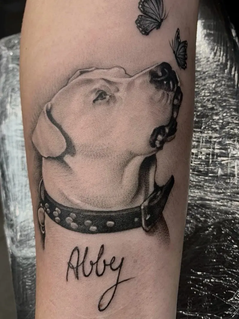 Realistinė juodai pilka šuns portreto tatuiruotė